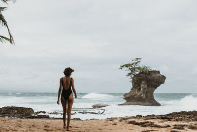 Rear view of man standing on beach