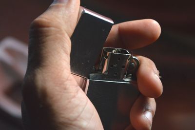 Close-up of man holding cigarette lighter