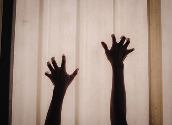 Close-up of silhouette hand touching tree