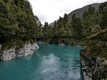 Scenic view of waterfall in forest against sky