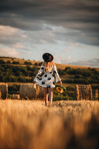 Rear view of woman standing on field