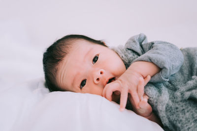 Portrait of cute baby lying on bed