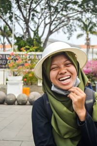 Portrait of a smiling young woman with a white bucket hat