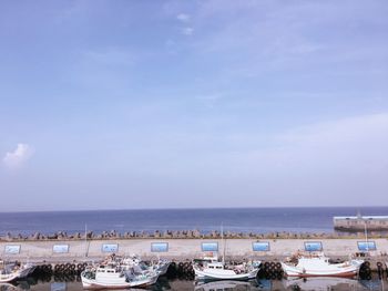 Boats moored on sea against blue sky