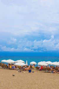 Beach umbrellas by sea against sky