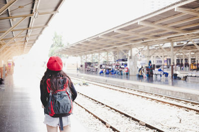 Rear view of woman standing on railroad station platform