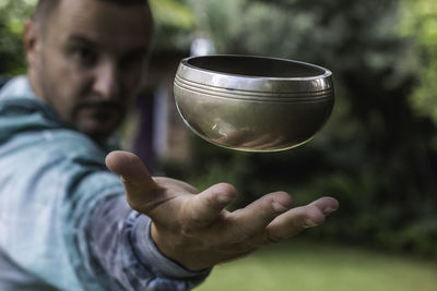 Midsection of man holding glass outdoors