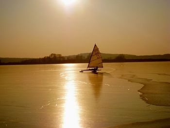 Boat sailing in sea at sunset