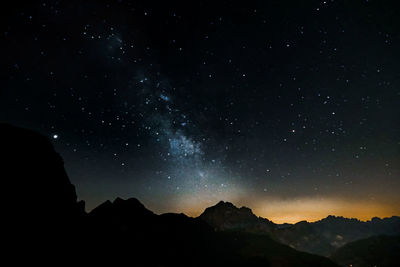 Scenic view of silhouette mountains against sky at night