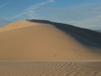 Sand dune in desert against sky