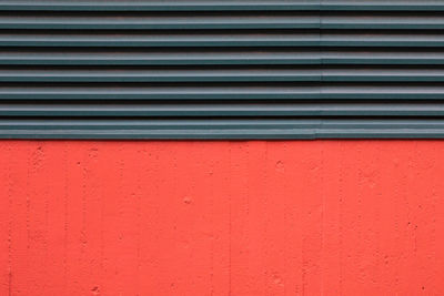 Full frame shot of red wall with air duct