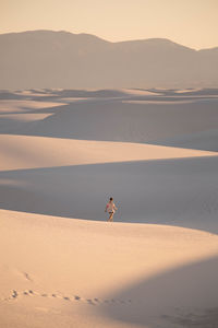 Young woman on sand dune in desert