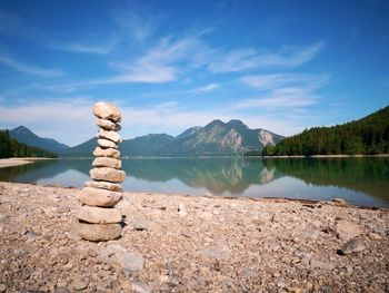 Stacked pebbles on the lake shore. balanced stones stack at water with reflection