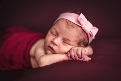 A newborn baby girl with a headband sleeping peacefully. newborn session concept