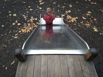 High angle view of boy on slide during autumn