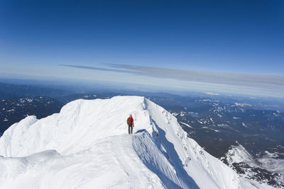 People on snowcapped mountain against sky