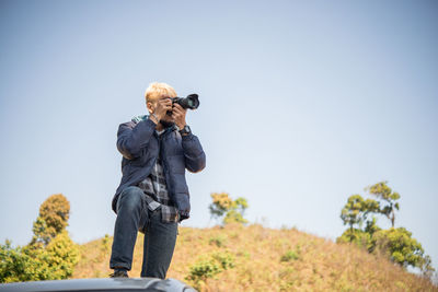 Man photographing against clear sky