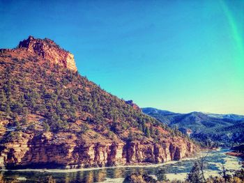 Scenic view of mountains against clear blue sky