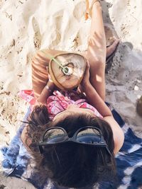 Directly above shot of woman holding coconut at beach