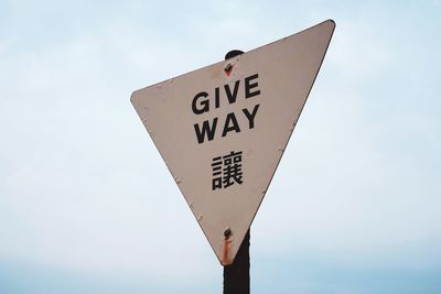 Low angle view of road sign against sky