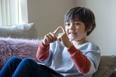 Boy sitting on sofa at home