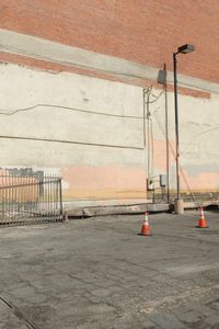 Electricity pylon by road against orange wall