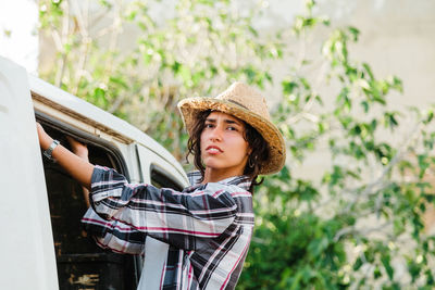 Portrait of young woman standing by motor van