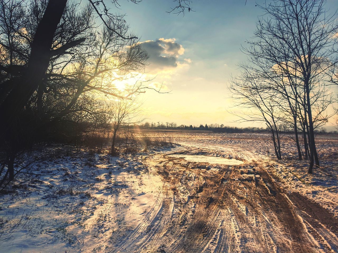 SCENIC VIEW OF SNOW FIELD AGAINST SKY AT SUNSET