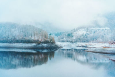 Scenic view of lake against sky during winter