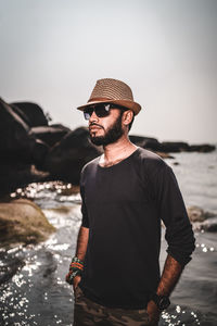 Man wearing hat standing at beach