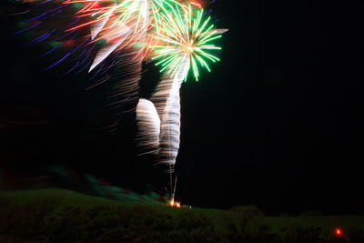 Low angle view of fireworks against sky at night