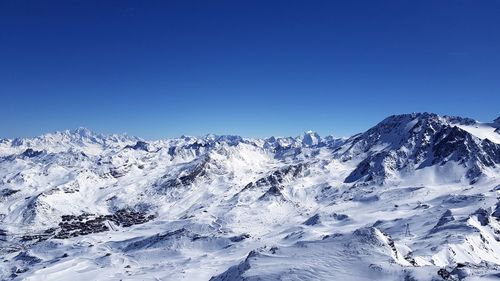 Scenic view of snowcapped mountains against clear blue sky