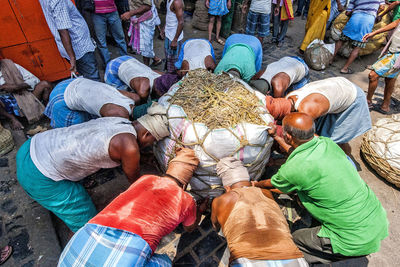 High angle view of people carrying sack on street at market