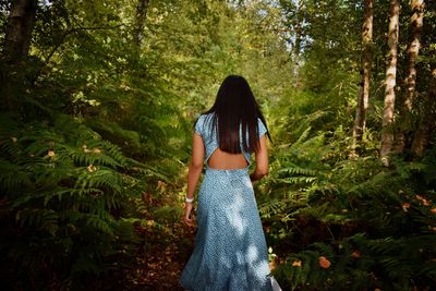 Rear view of woman walking in forest