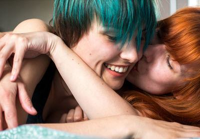 Close-up of happy lesbian couple lying on bed