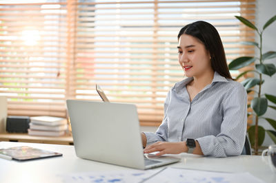 Young woman using laptop at office