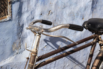 Close-up of rusty bicycle against wall