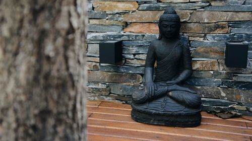 Statue against brick wall