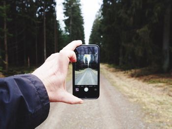 Close-up of man using mobile phone in forest