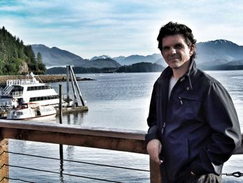 Portrait of smiling young man in lake against sky