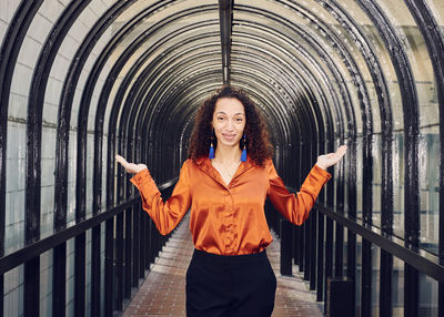 Portrait of woman standing against railing