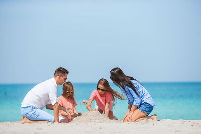 People on beach against clear sky