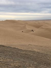 View of desert against cloudy sky