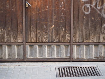 Closed wooden door by footpath