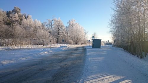 Scenic view of snow covered empty road