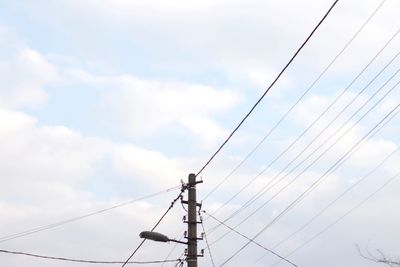 Low angle view of electricity pylon against sky