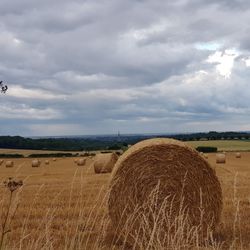 Hay bales on field against sky