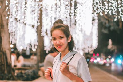 Portrait of happy girl standing against trees