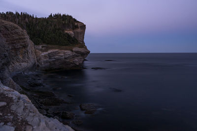 Rock formation in sea against sky