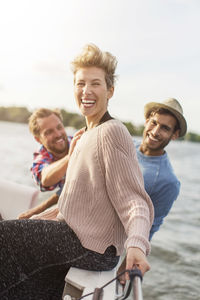 Portrait of happy woman enjoying with friends on yacht